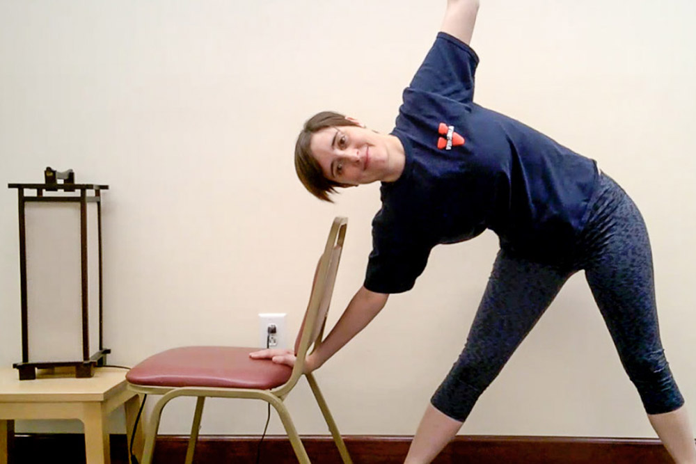 Anna Kutcher, an instructor in Jill Howie-Esquivel's heart failure study, stretches sideways while leaning on a chair