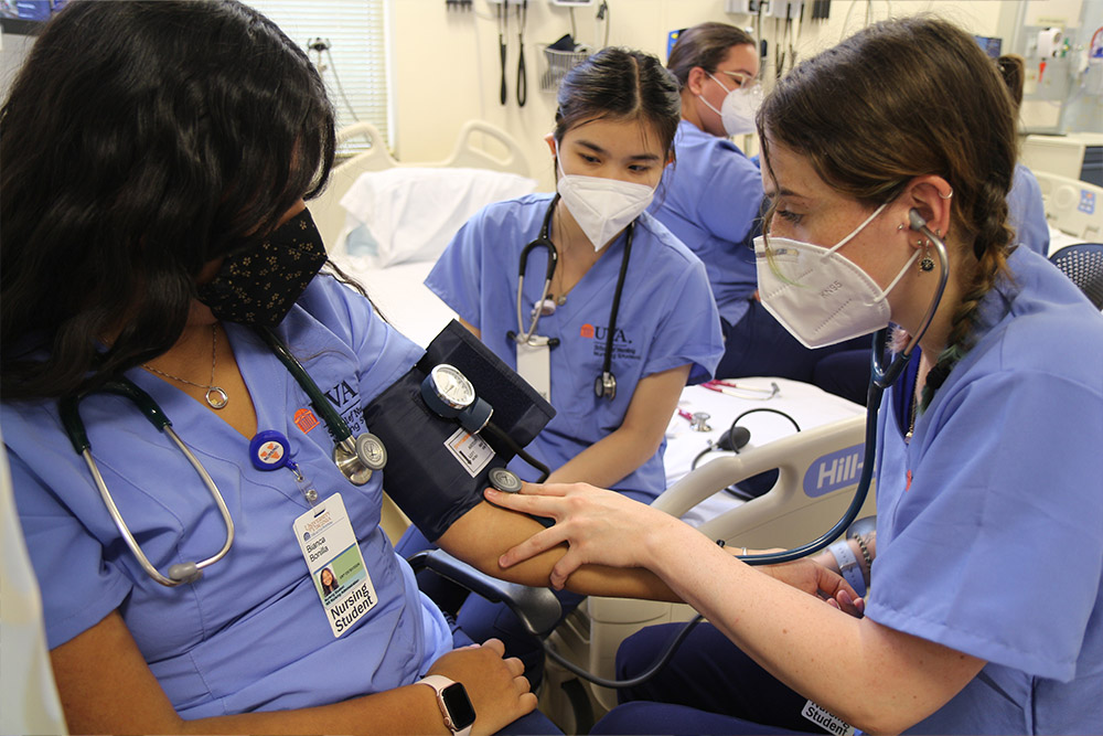 BSN students assess one another's blood pressure.