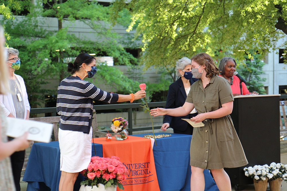 A members of the BSN Class of 2021 receives a rose from Lynn Coyner.