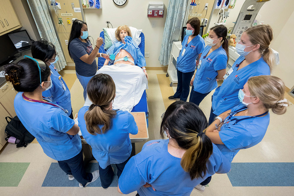 BSN students gathered around a patient bedside in the CSLC