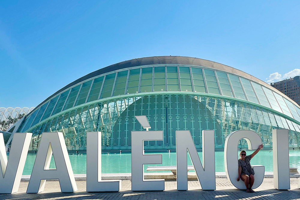 BSN Class of 23 nursing student Clara Keely in Valencia Spain sitting in front of the Ciudad of Artesy Ciencia sign.