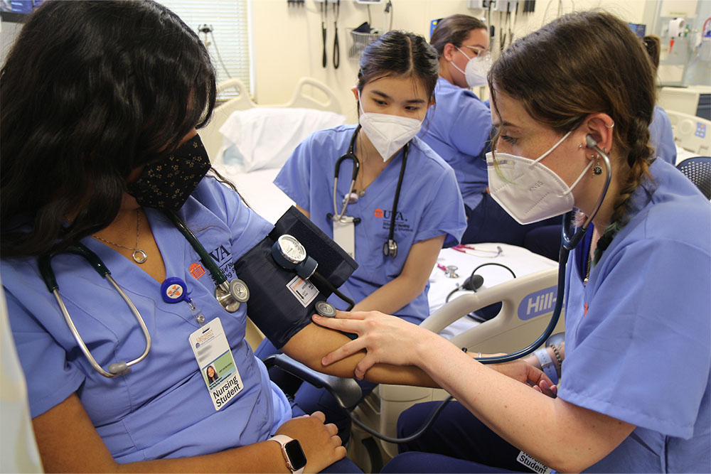 Nursing students in the ABSN program practicing reading blood pressure