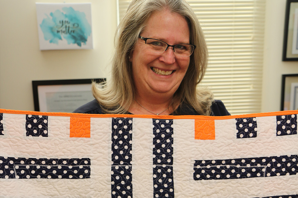 Julie Haizlip with a quilt that a former DNP student made for her. Mattering