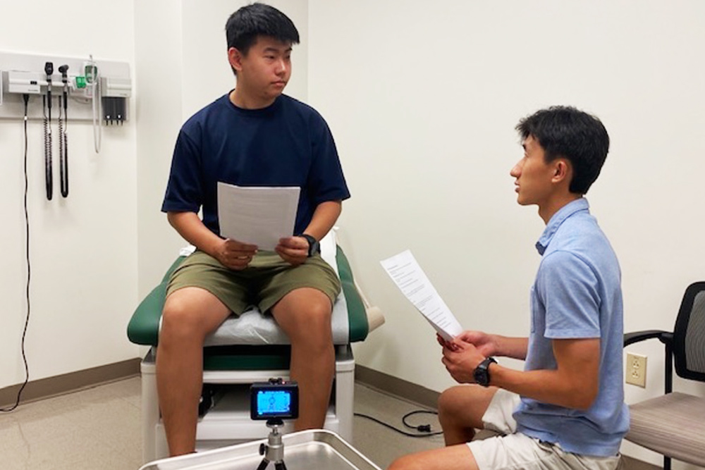 Two members of the study team, medical student David Lee, and PhD engineering student Zhiyuan Wang, demonstrate pilot testing of the CommSense technology.