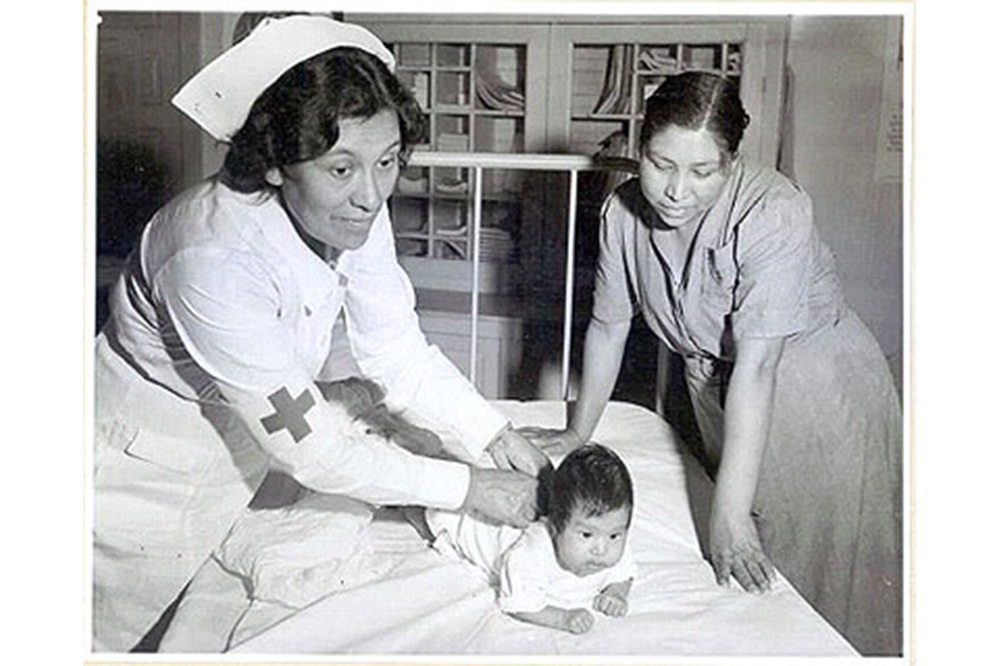 Nurse Lula Owl examines a child in 1942
