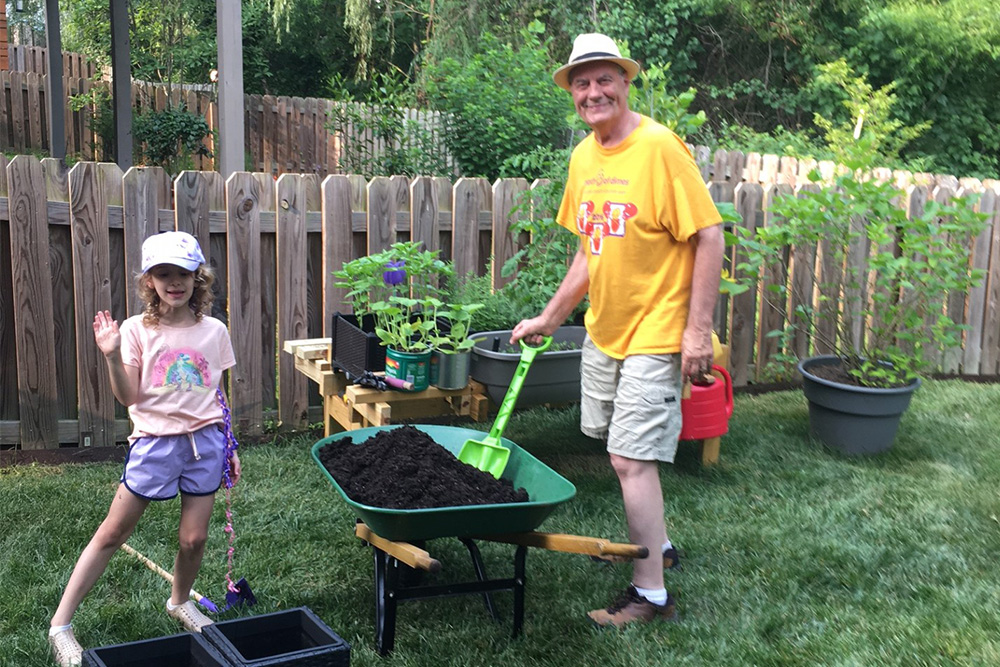 Prof Richard Ridge gardening with his granddaughter.