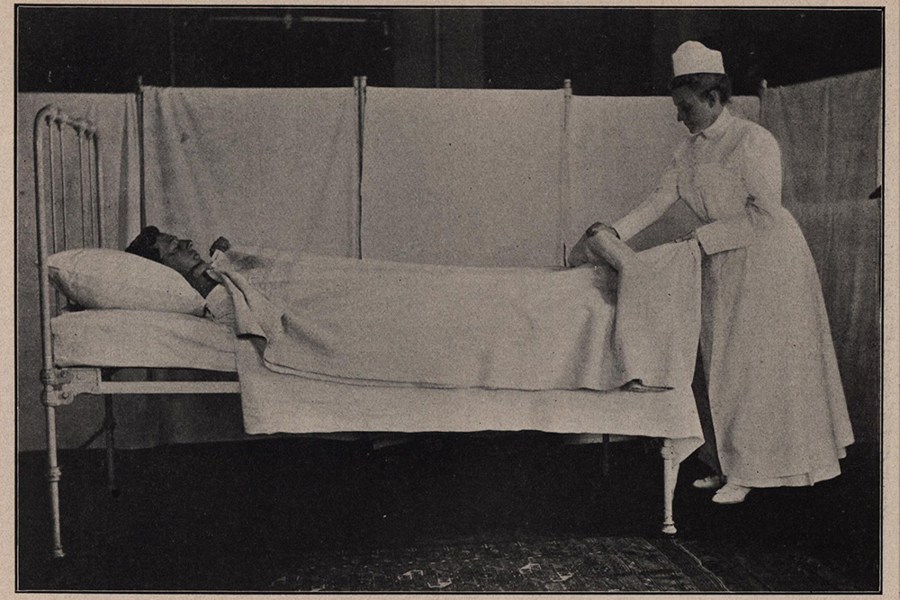 Bedmaking around a bedridden patient.
