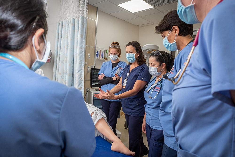 An image of CNL students during a labor and delivery simulation with prof. Suzanne Wentworth.