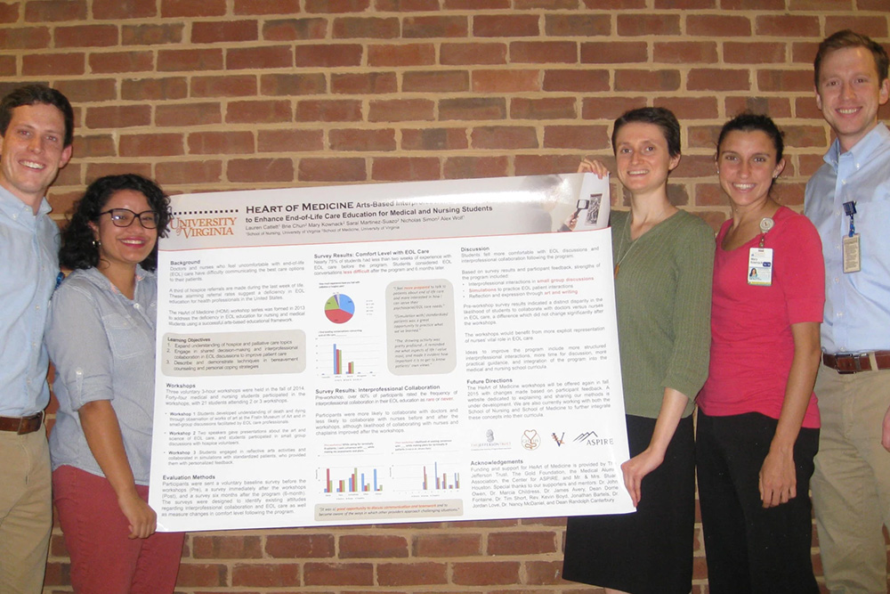 Heart of Medicine nursing and medical students hold a poster with their research, includign DNP grad and nurse pracittioner Alex Wolf and Lauren Catlett, CNL graduate and a PhD in nursing student