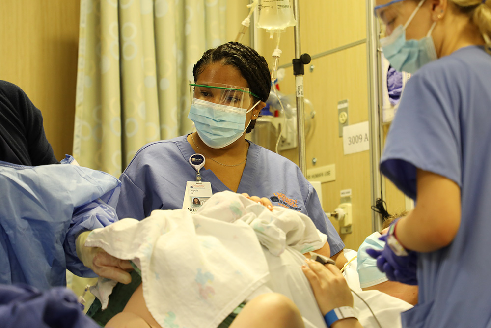 Nursing students tend an actor standardized patient as part of an OB sim.