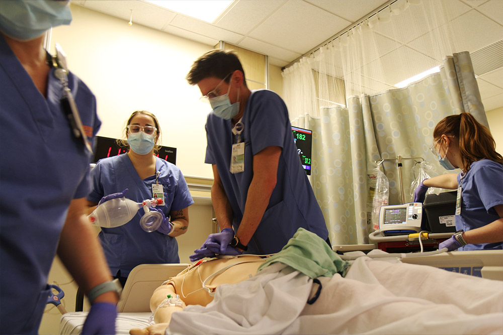 CNL students practice tending a patient who is coding in the sim lab.