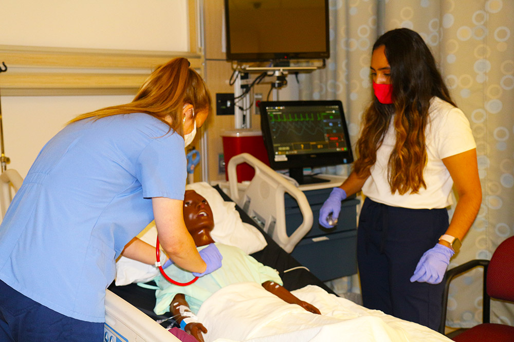 CNL student Angie Limas tends a pediatric patient in the sim lab.