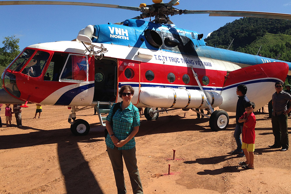 Terri Yost in Vietnam, standing in front of a helicopter.
